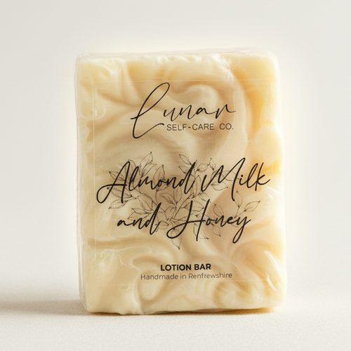A lotion bar packaged in clear wrapping with the brand 'Lunar Self-Care Co.' and the product name 'Almond Milk and Honey' written in elegant script.
