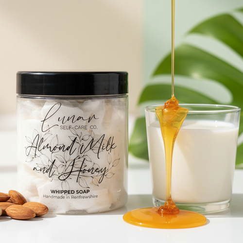 Lunar Self-Care Co. Almond Milk and Honey whipped soap with almonds and a glass of milk on a white surface.