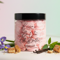 Jar of 'La Vie Est Belle' whipped soap with vanilla beans and flowers on a light background