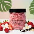 Pink Raspberry Vanilla scented whipped soap in plastic jar surrounded by fresh strawberries, raspberries and vanilla pods.