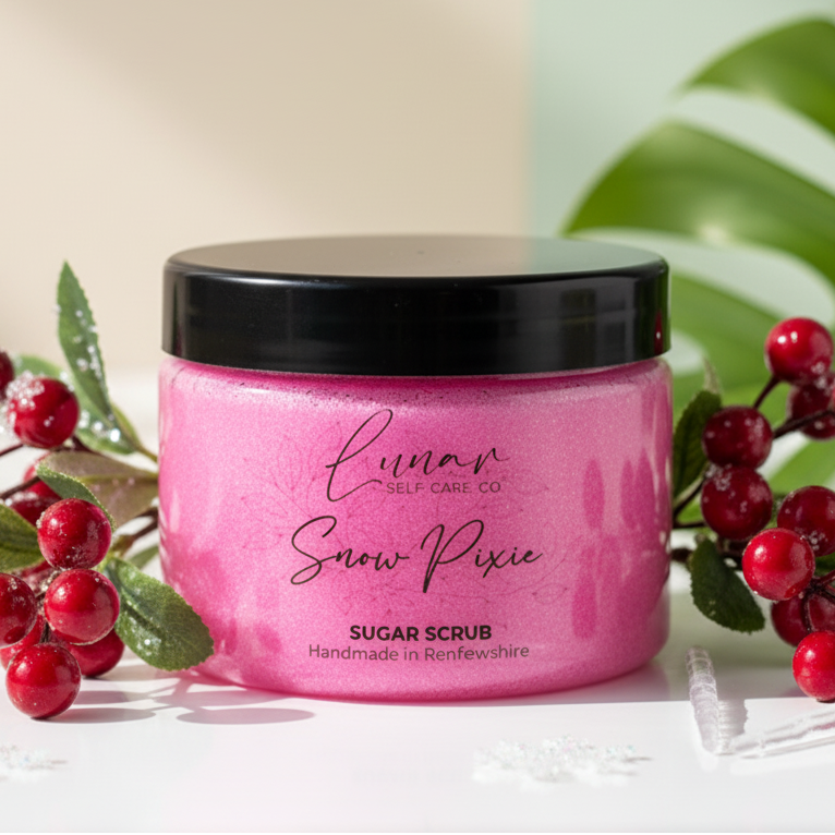 Pink sugar scrub jar with black lid surrounded by red berries and green leaves on a light background