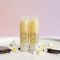 Two lip balm tubes labeled 'Vanilla' on a textured white background